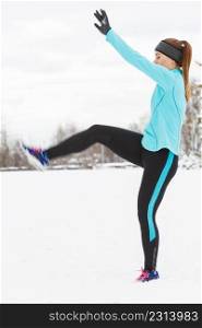 Girl exercising in park, legs stretching exercises. Winter sports, outdoor fitness, fashion, nature workout, health concept.. Winter sport, girl exercising in park