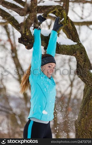Girl exercising on tree. Winter sports, outdoor fitness, fashion, health concept.. Winter sports, girl exercising on tree.