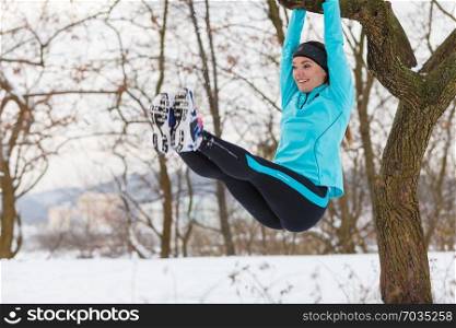 Girl exercising on tree. Winter sports, outdoor fitness, fashion, health concept.. Winter sports, girl exercising on tree.