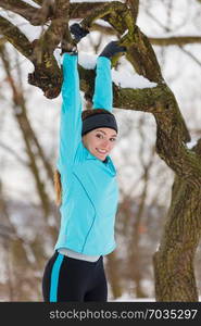 Girl exercising on tree. Winter sports, outdoor fitness, health concept.. Winter sports, girl exercising on tree.