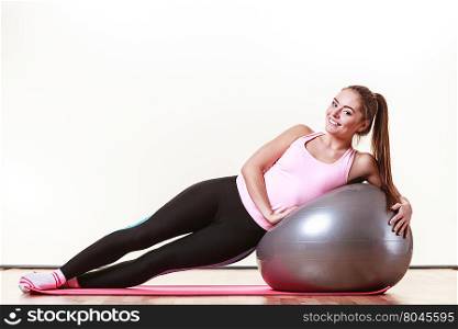 Girl exercising with fit ball. Sport exercises workout health concept. Tired girl resting. Exhausted lady catching a breath after exercising with fitness ball.