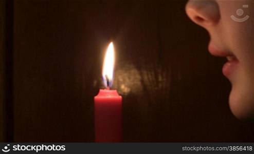 girl extinguishes a burning candle.