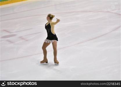 Girl figure skater rolls on a skating rink with artificial ice