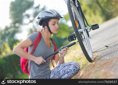 girl fixing bicycle tire outside