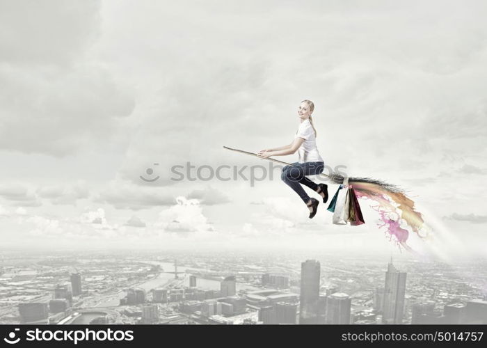 Girl fly on broom. Happy young woman flying in sky on broom