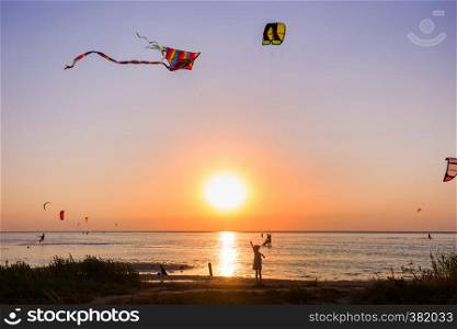 girl flying a kite on the sea in sunset time