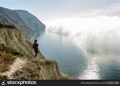 Girl from the mountain watching the clouds above the sea