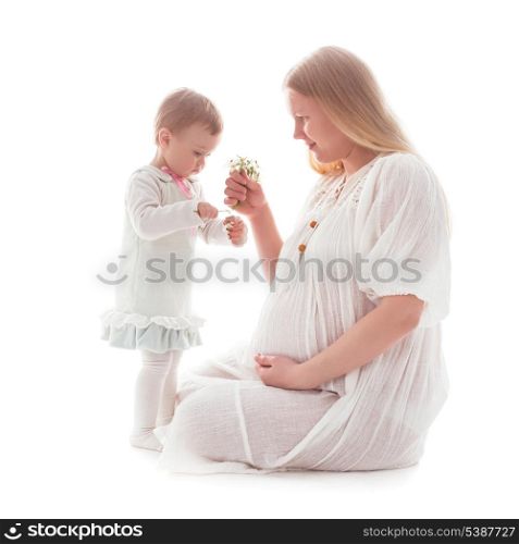Girl gives snowdrops to pregnant mother, isolated on white