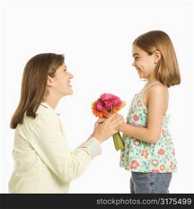 Girl giving bouquet of flowers to mother.