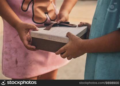Girl giving gift box to boy