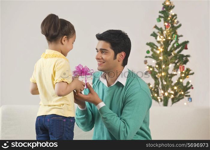 Girl giving gift to father