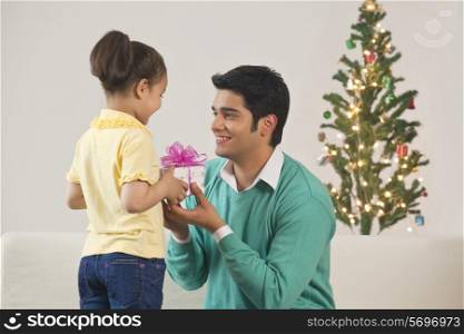 Girl giving gift to father