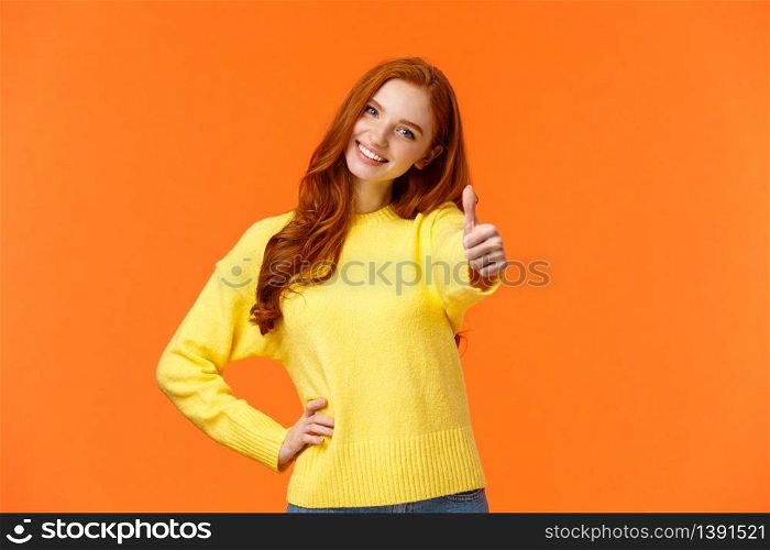 Girl giving permission, say yes. Cheerful redhead woman in yellow sweater extend arm and show thumb-up, smiling nod agreement, give approval, like idea, standing orange background joyful.. Girl giving permission, say yes. Cheerful redhead woman in yellow sweater extend arm and show thumb-up, smiling nod agreement, give approval, like idea, standing orange background joyful