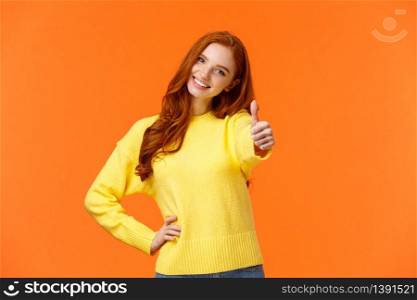 Girl giving permission, say yes. Cheerful redhead woman in yellow sweater extend arm and show thumb-up, smiling nod agreement, give approval, like idea, standing orange background joyful.. Girl giving permission, say yes. Cheerful redhead woman in yellow sweater extend arm and show thumb-up, smiling nod agreement, give approval, like idea, standing orange background joyful