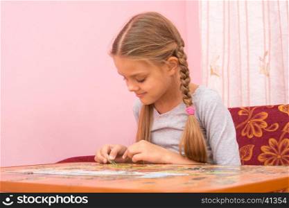 Girl gladly collect picture of puzzles