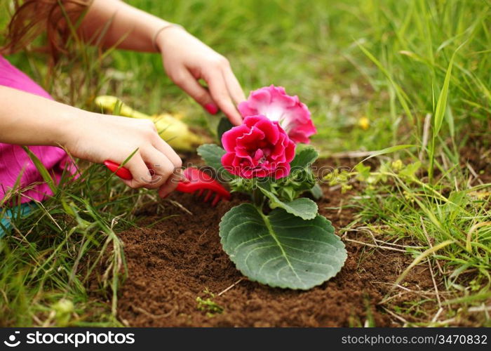 girl grow flower on green field