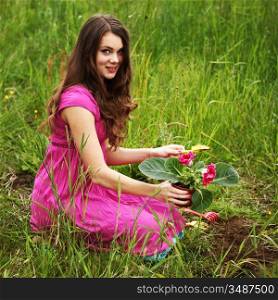 girl grow flower on green field