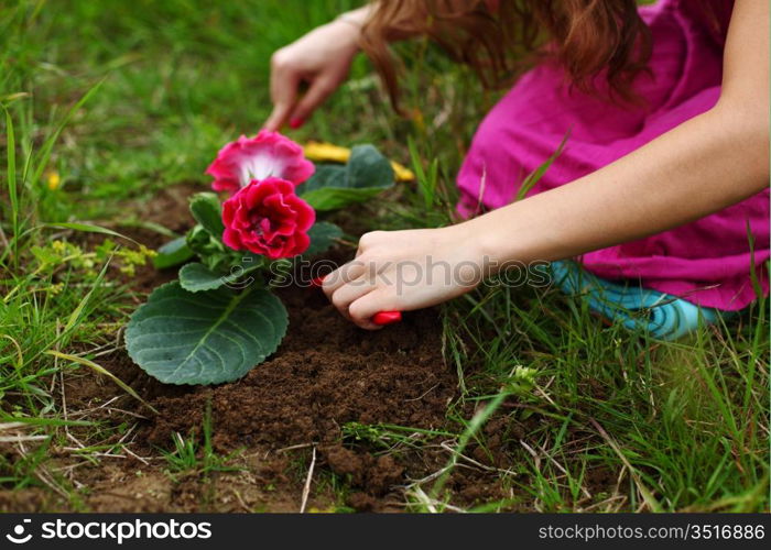 girl grow flower on green field