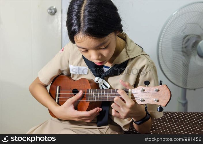 Girl hand playing ukulele. Ukulele have gained a lot of popularity. Ukulele eventually changed from native Hawaiian instruments to international instruments.