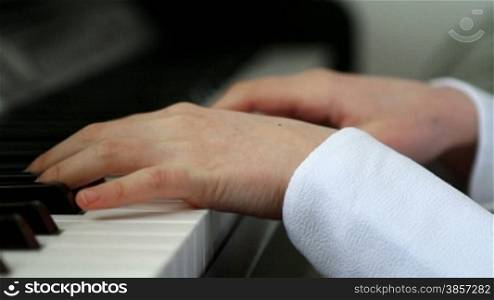 Girl hands playing piano close up