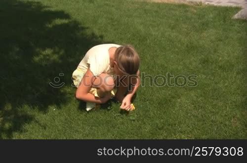 girl has found a flower in a grass.