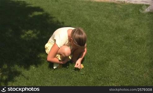 girl has found a flower in a grass.