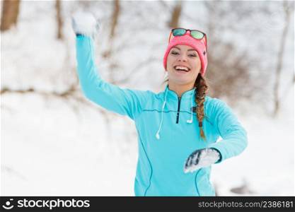 Girl has fun throwing snowballs. Relax in winter park. Health nature fitness fashion concept. . Girl has fun throwing snowballs