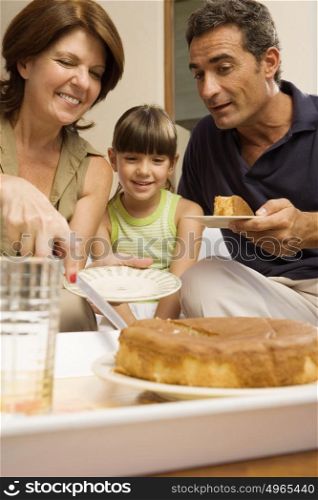 Girl having cake with grandparents