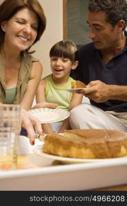 Girl having cake with grandparents