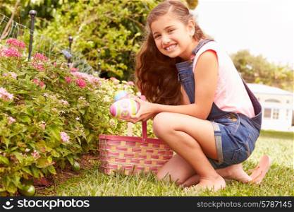 Girl Having Easter Egg Hunt In Garden