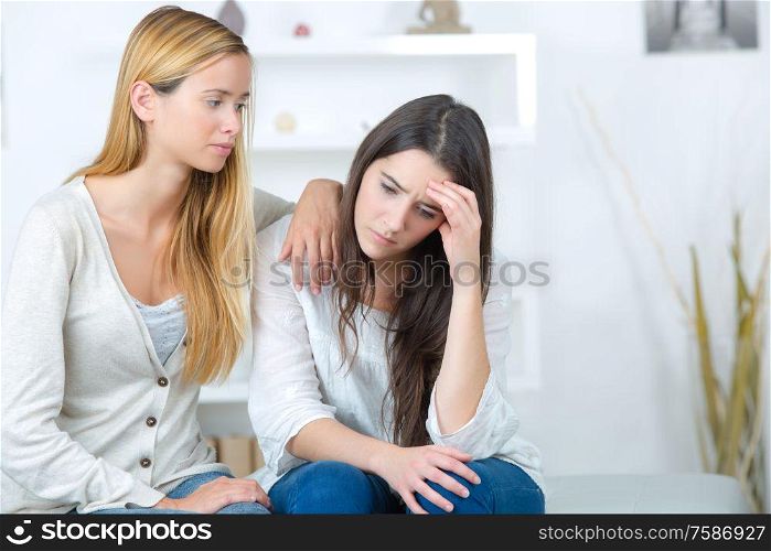 girl helping her sad sister with problems
