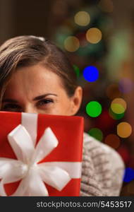 Girl hiding behind Christmas present box