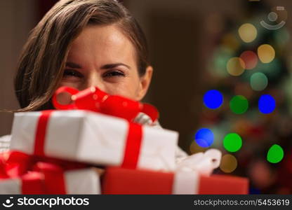 Girl hiding behind Christmas present boxes