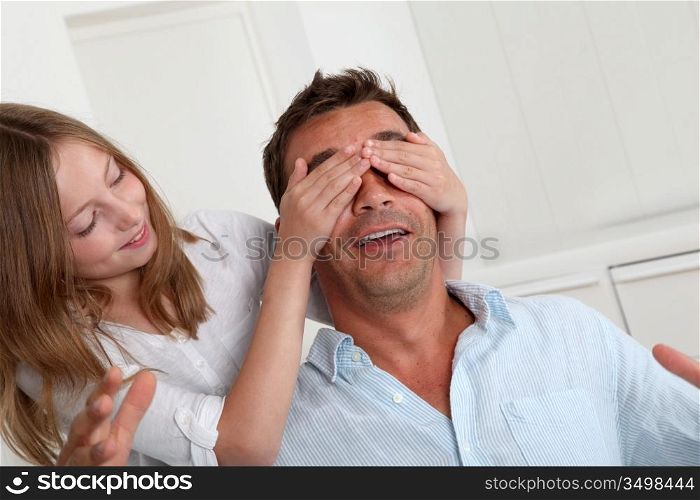 Girl hiding her father&acute;s eyes