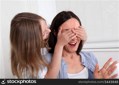 Girl hiding her mother&acute;s eyes