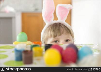 girl hiding table with easter eggs