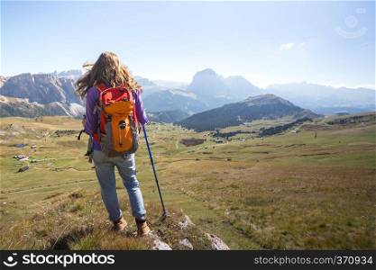 girl hiker at the mountains Dolomites and views of the valley, Italy. Seceda 