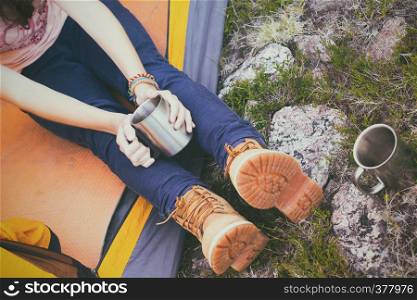 girl hiker in a tent and holding a cup