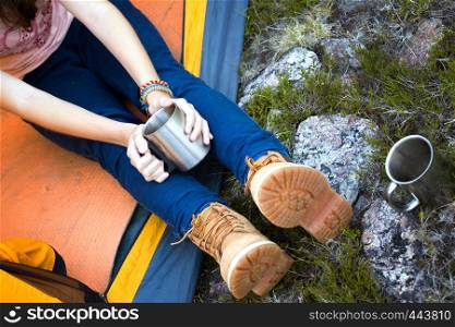 girl hiker in a tent and holding a cup