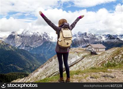 girl hiker looking at the snowed mountains. Dolomites, Italy.