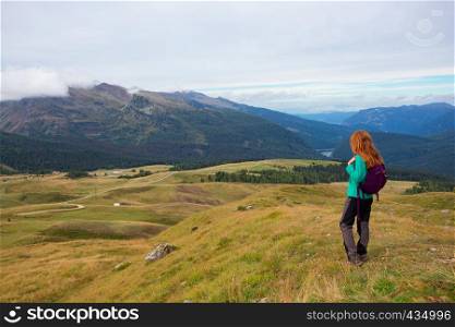 girl hiker on a trail at the Dolomites mountains