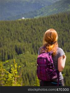 girl hiker with a backpack standing on the background of mountains and forests. Ukrainian landscape.