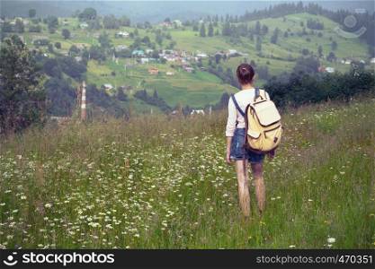 girl hiker with a backpack walking in the mountains. Vorokhta - Ukrainian landscape.