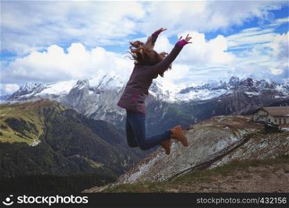 girl hikers jumping at the mountains Dolomites, Italy.