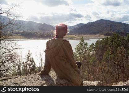 girl hipster sits on the background of Romanian Carpathians mountains