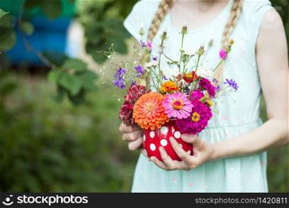 girl holding a beautiful bright bouquet of wildflowers in her hands