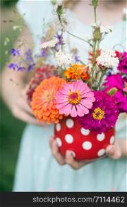 girl holding a beautiful bright bouquet of wildflowers in her hands