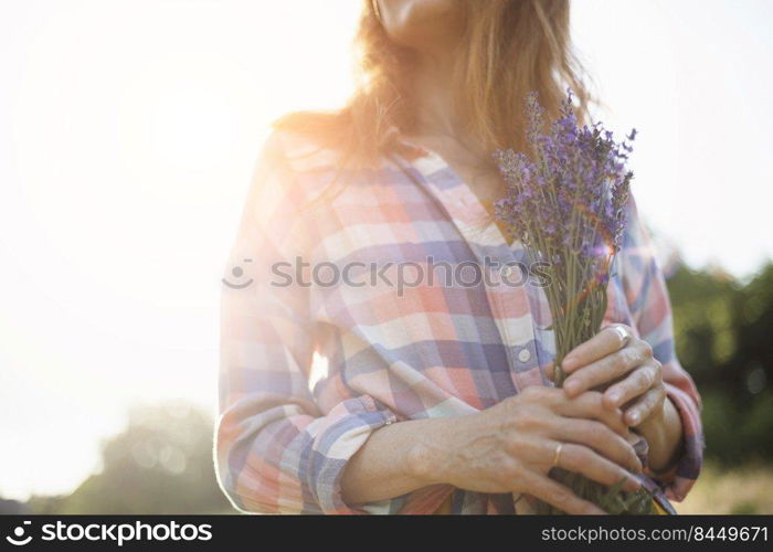 girl holding a bouquet of lavender against the backdrop of sunset 