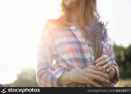 girl holding a bouquet of lavender against the backdrop of sunset 