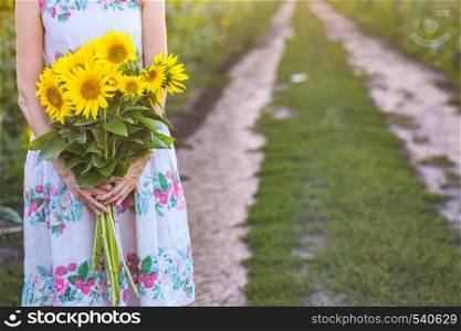 girl holding a huge bouquet of sunflowers in their hands